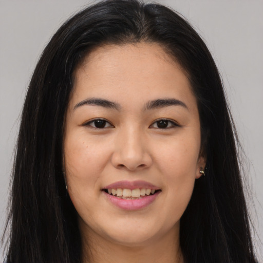 Joyful asian young-adult female with long  brown hair and brown eyes