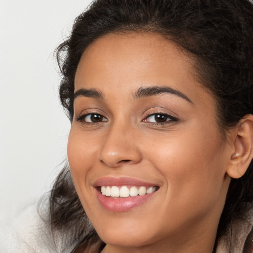 Joyful latino young-adult female with long  brown hair and brown eyes