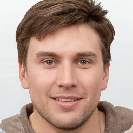 Joyful white young-adult male with short  brown hair and grey eyes