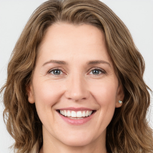 Joyful white young-adult female with long  brown hair and green eyes