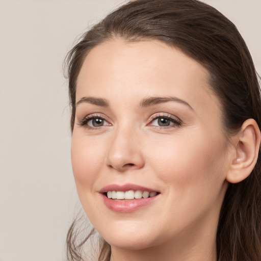 Joyful white young-adult female with long  brown hair and brown eyes