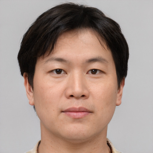 Joyful asian adult male with short  brown hair and brown eyes