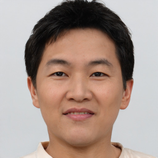 Joyful asian young-adult male with short  brown hair and brown eyes