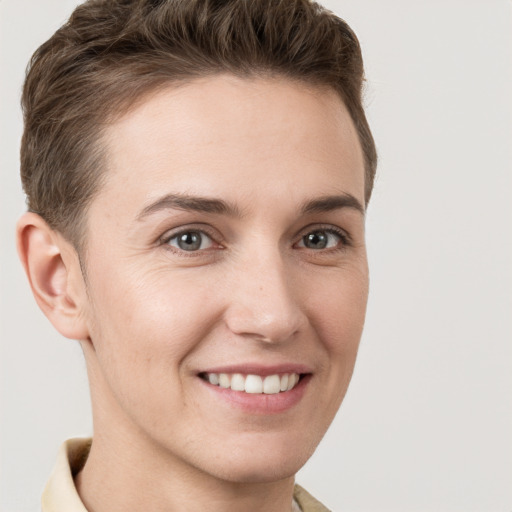 Joyful white young-adult female with short  brown hair and grey eyes