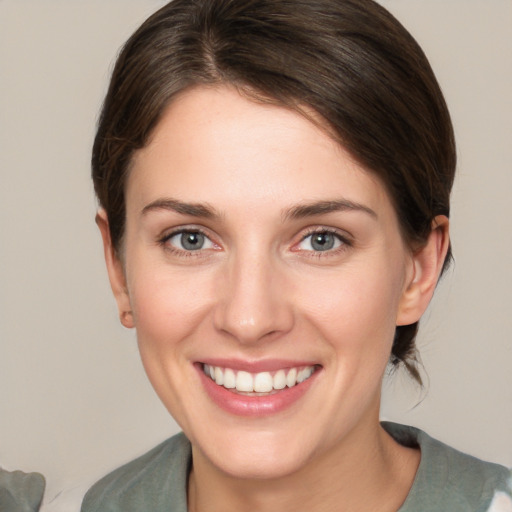 Joyful white young-adult female with medium  brown hair and grey eyes