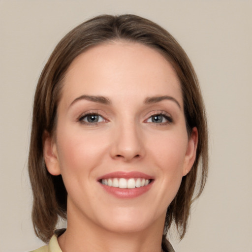 Joyful white young-adult female with medium  brown hair and green eyes