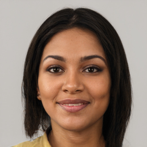 Joyful black young-adult female with long  brown hair and brown eyes