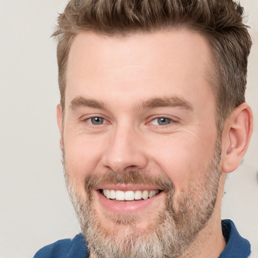 Joyful white adult male with short  brown hair and grey eyes