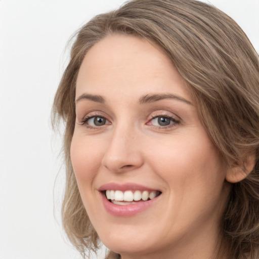 Joyful white young-adult female with long  brown hair and green eyes