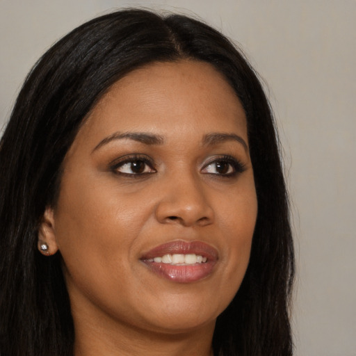Joyful black young-adult female with long  brown hair and brown eyes