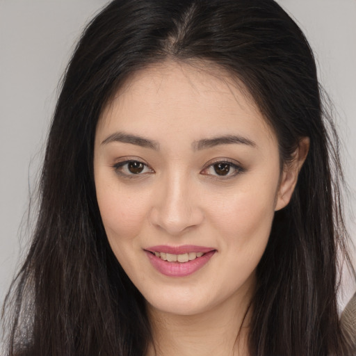 Joyful asian young-adult female with long  brown hair and brown eyes