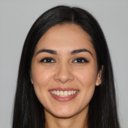 Joyful latino young-adult female with long  brown hair and brown eyes