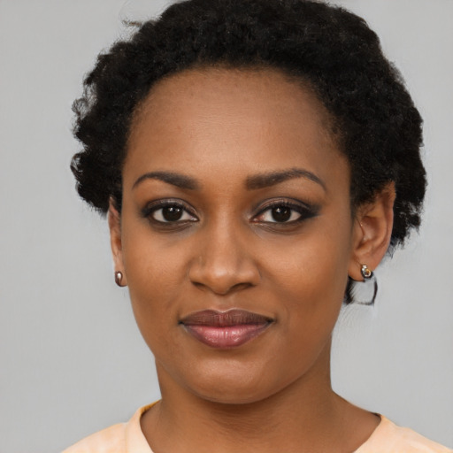 Joyful black young-adult female with short  black hair and brown eyes