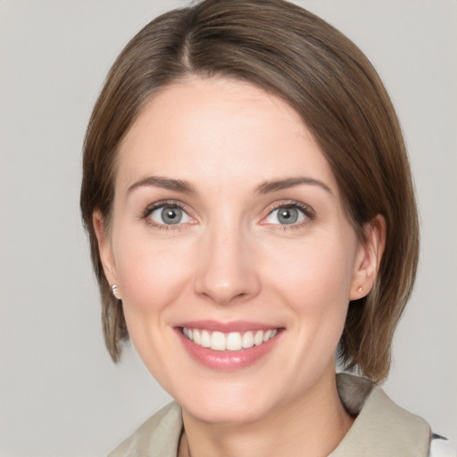 Joyful white young-adult female with medium  brown hair and grey eyes