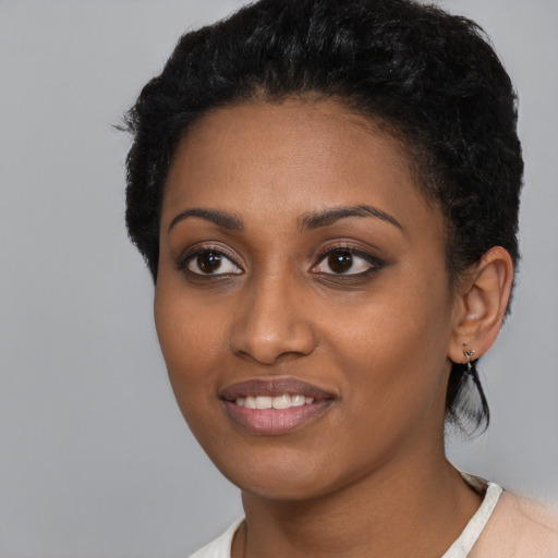 Joyful black young-adult female with short  black hair and brown eyes