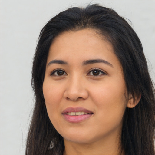 Joyful latino young-adult female with long  brown hair and brown eyes