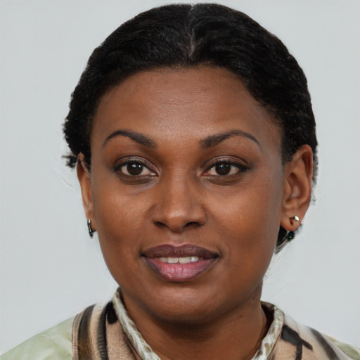 Joyful black young-adult female with short  black hair and brown eyes