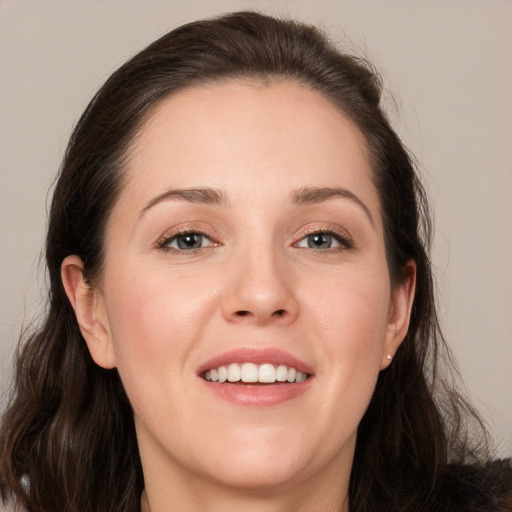 Joyful white young-adult female with long  brown hair and brown eyes