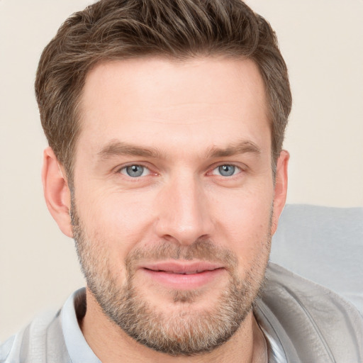 Joyful white young-adult male with short  brown hair and grey eyes