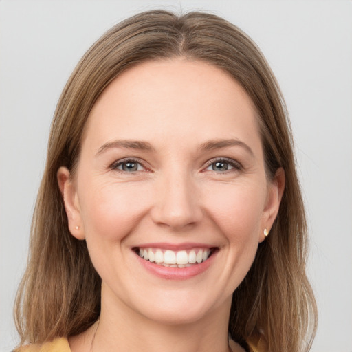 Joyful white young-adult female with long  brown hair and grey eyes