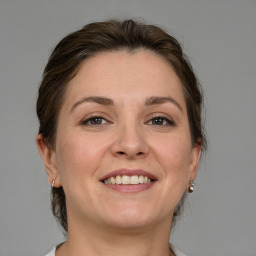 Joyful white adult female with medium  brown hair and grey eyes