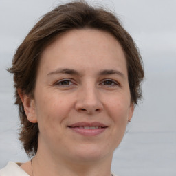 Joyful white adult female with medium  brown hair and brown eyes