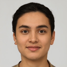 Joyful latino young-adult male with short  brown hair and brown eyes