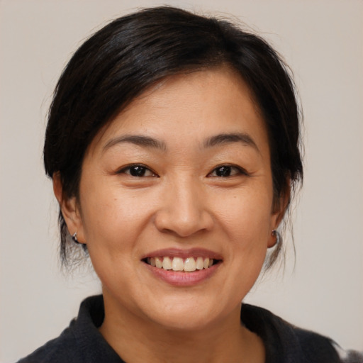 Joyful asian adult female with medium  brown hair and brown eyes