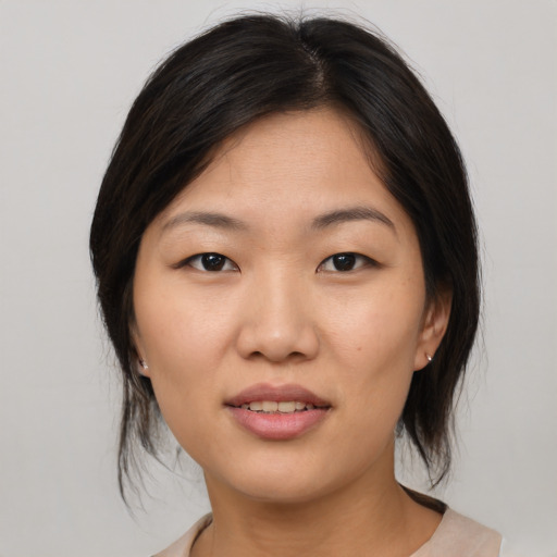 Joyful asian young-adult female with medium  brown hair and brown eyes
