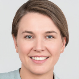 Joyful white young-adult female with short  brown hair and grey eyes