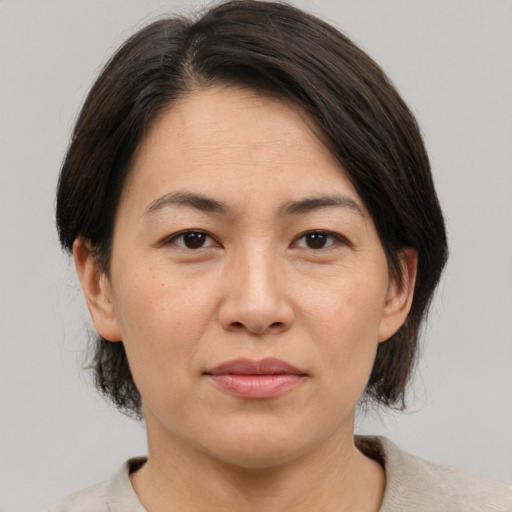Joyful asian adult female with medium  brown hair and brown eyes