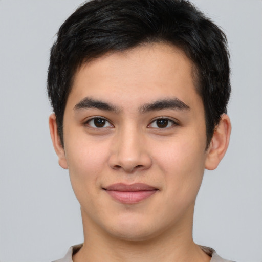 Joyful asian young-adult male with short  brown hair and brown eyes