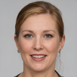 Joyful white adult female with medium  brown hair and grey eyes