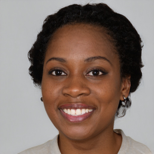 Joyful black young-adult female with medium  black hair and brown eyes