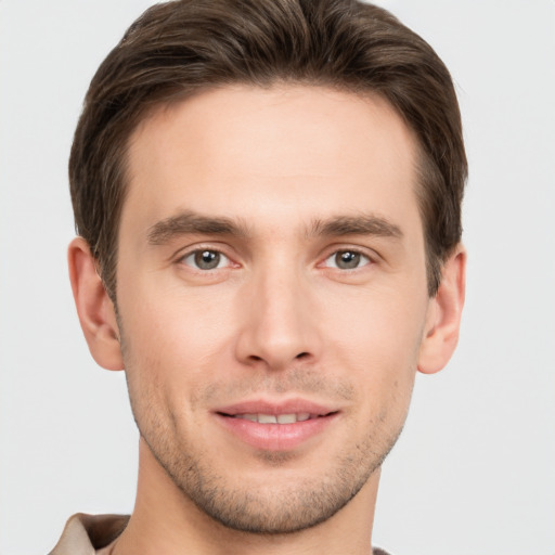 Joyful white young-adult male with short  brown hair and grey eyes