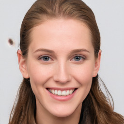 Joyful white young-adult female with long  brown hair and blue eyes