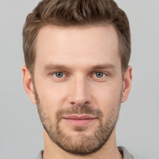 Joyful white young-adult male with short  brown hair and grey eyes