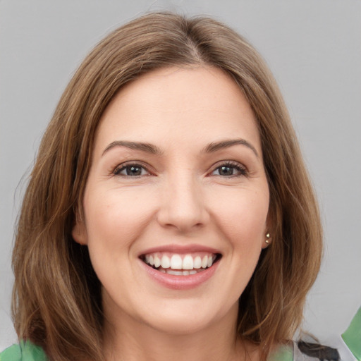 Joyful white young-adult female with medium  brown hair and green eyes