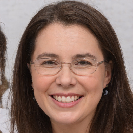 Joyful white adult female with long  brown hair and brown eyes