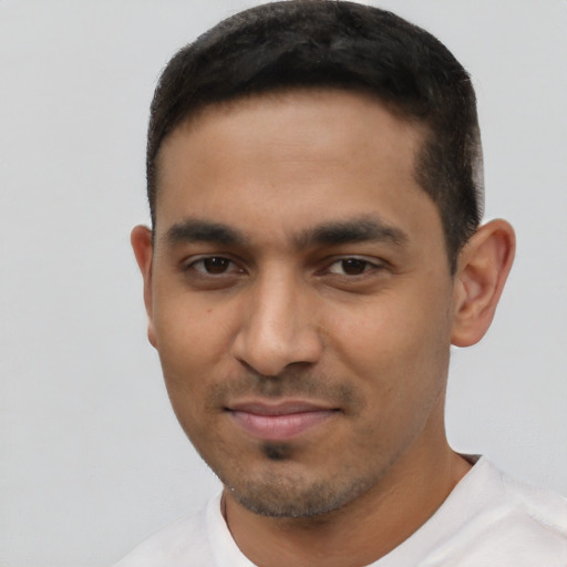 Joyful latino young-adult male with short  black hair and brown eyes