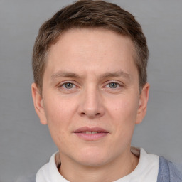 Joyful white young-adult male with short  brown hair and grey eyes