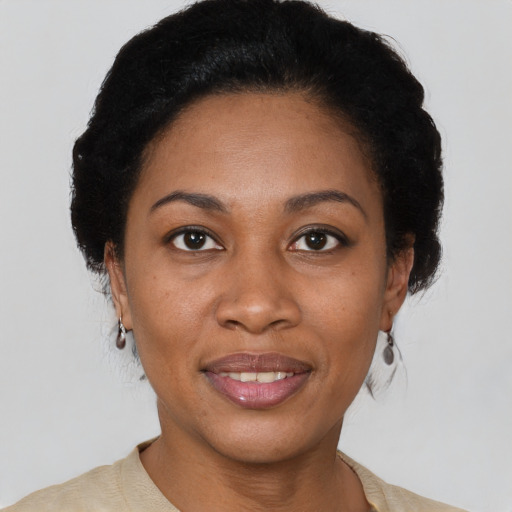 Joyful black adult female with short  black hair and brown eyes