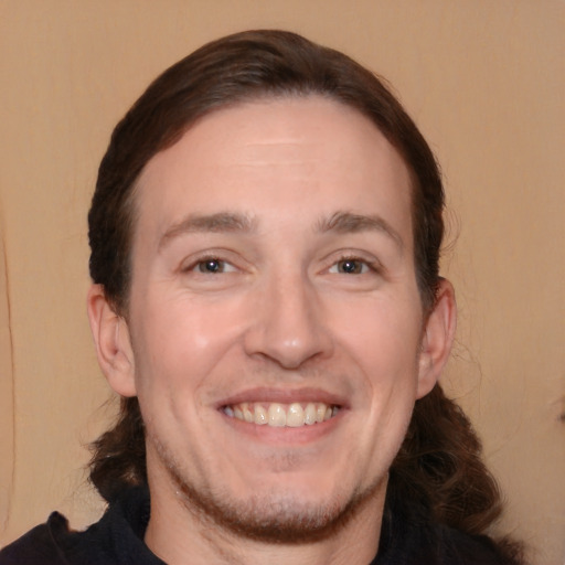 Joyful white adult male with medium  brown hair and brown eyes