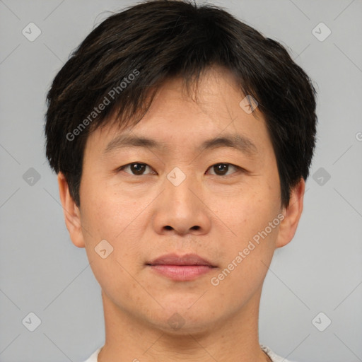 Joyful asian young-adult male with short  brown hair and brown eyes