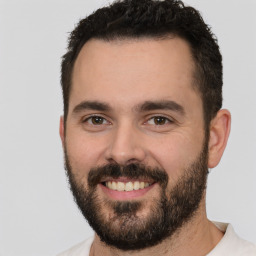 Joyful white young-adult male with short  black hair and brown eyes