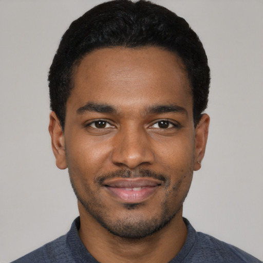Joyful black young-adult male with short  black hair and brown eyes
