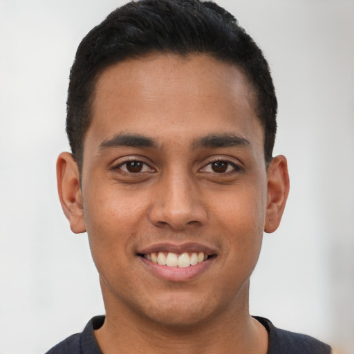Joyful latino young-adult male with short  black hair and brown eyes