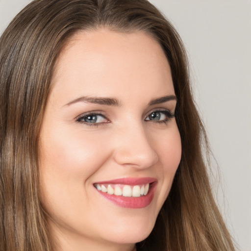 Joyful white young-adult female with long  brown hair and brown eyes