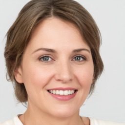 Joyful white young-adult female with medium  brown hair and green eyes