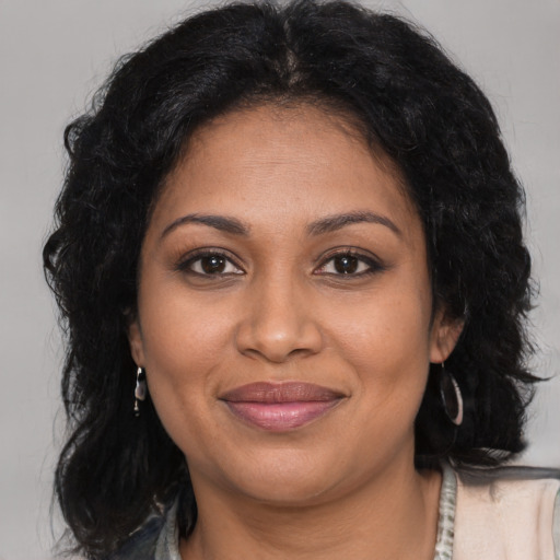 Joyful black adult female with long  brown hair and brown eyes